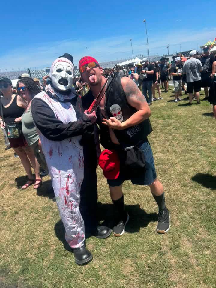 Art the Clown with a fan holding a crossbow at Daytona Speedway