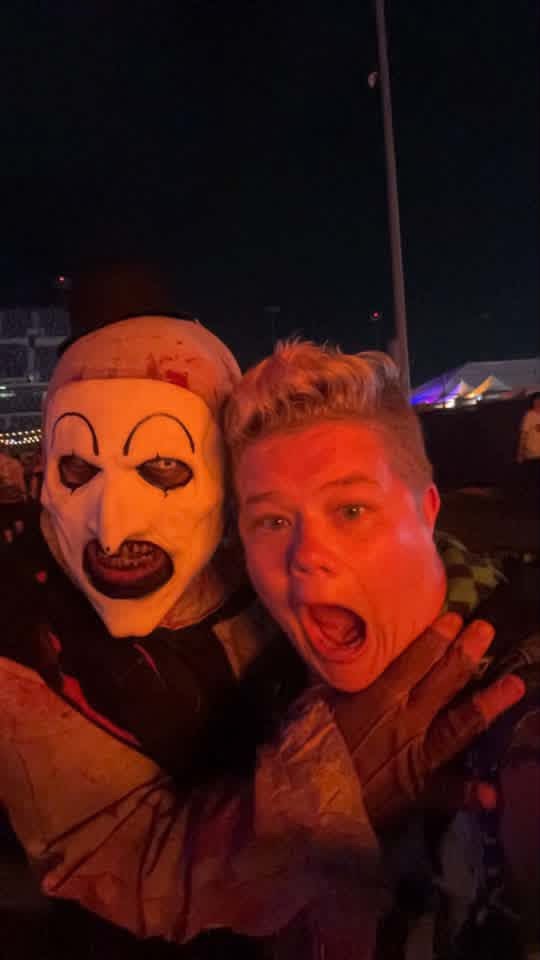 Night selfie: Art the Clown headlocking a screaming fan under red lights