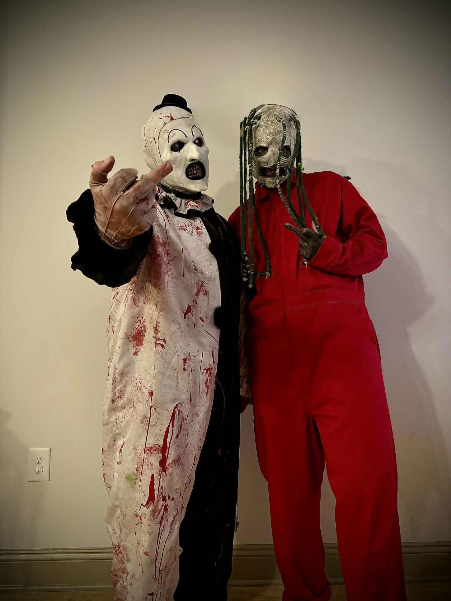 Aleksandr in full costume next to a friend in a red jumpsuit mask