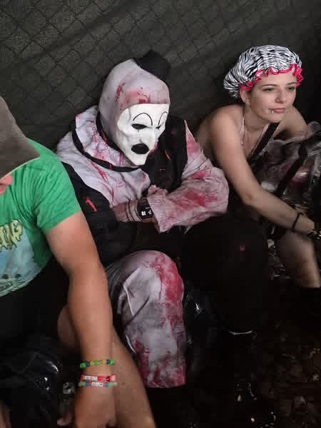 Art the Clown resting in the shade of a tent with festival friends
