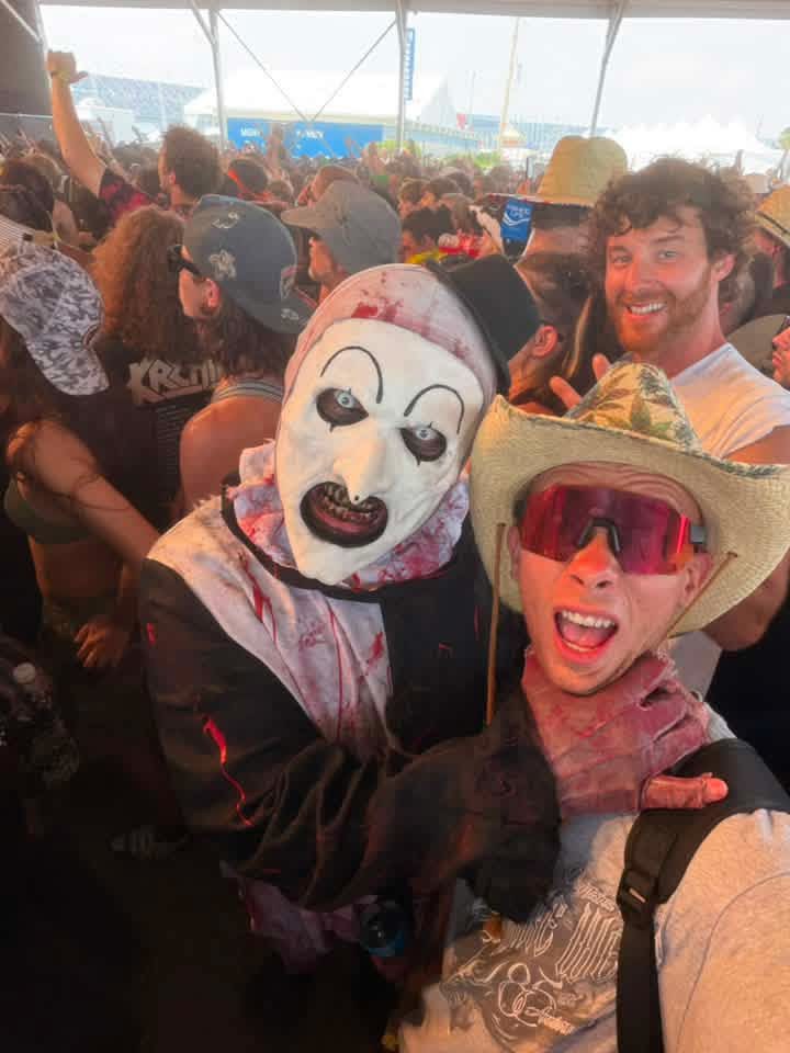 Crowd selfie: Art the Clown with a fan in a straw cowboy hat under the tent