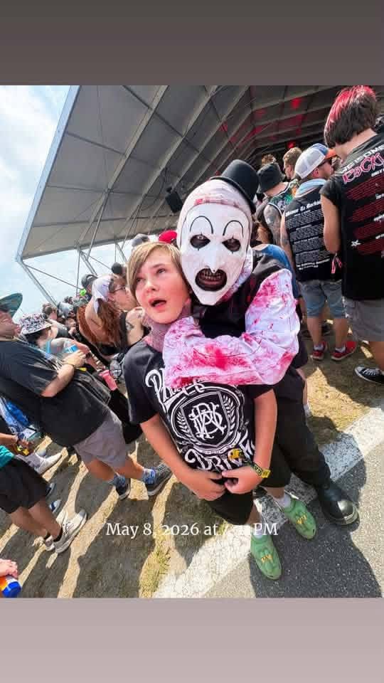 A kid carrying Art the Clown on his back in the daytime crowd