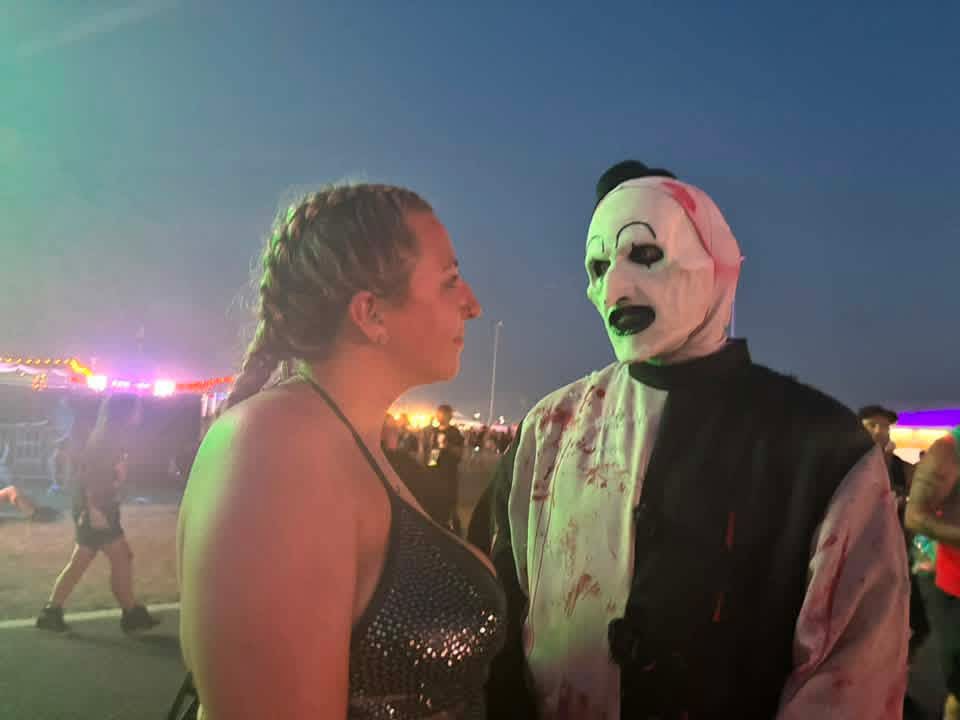 Art the Clown staring down a fan under green and purple lights