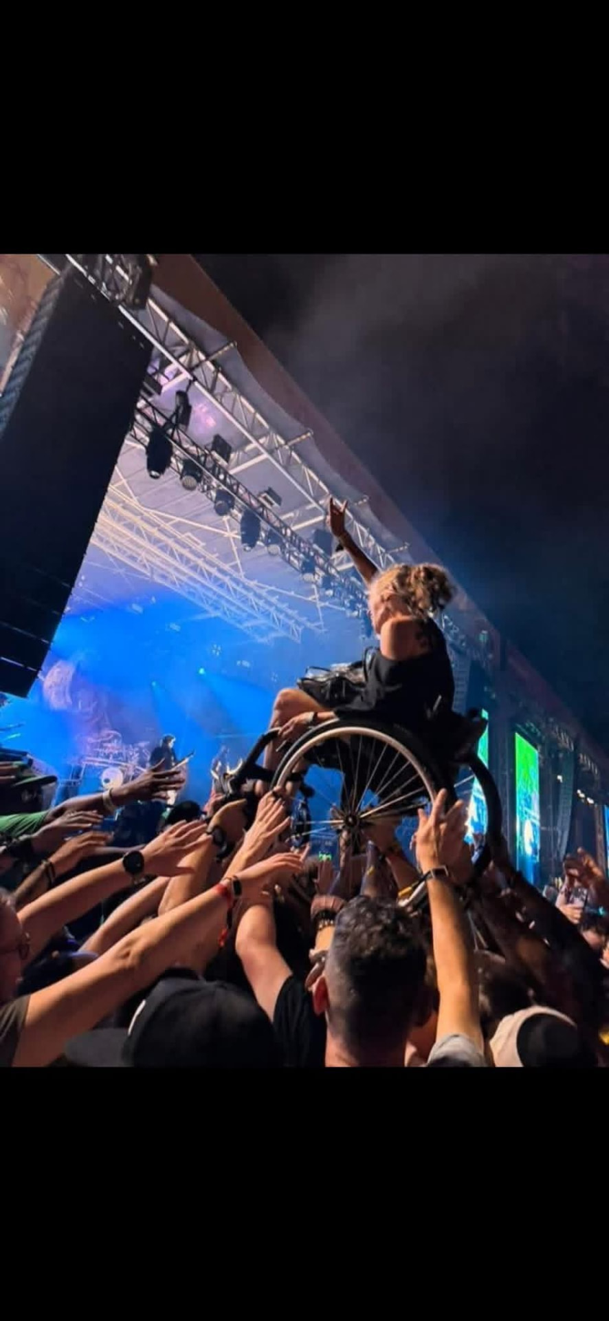 Fan in a wheelchair crowd-surfing over the pit at the main stage