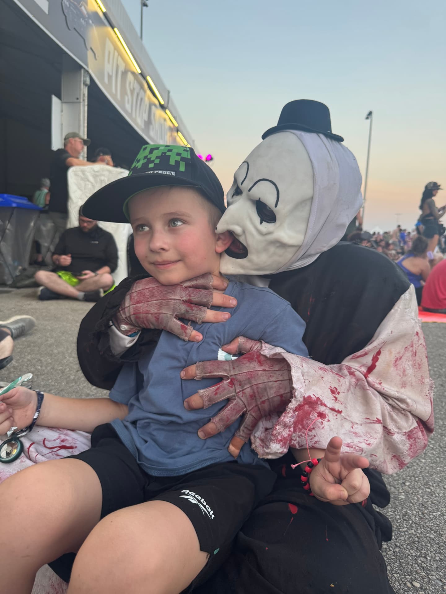 Aleksandr in costume holding his young son at the speedway