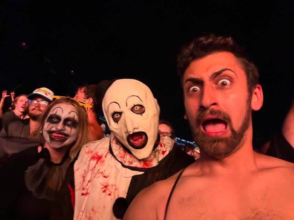 Night selfie: Art the Clown screaming with two clown-painted fans
