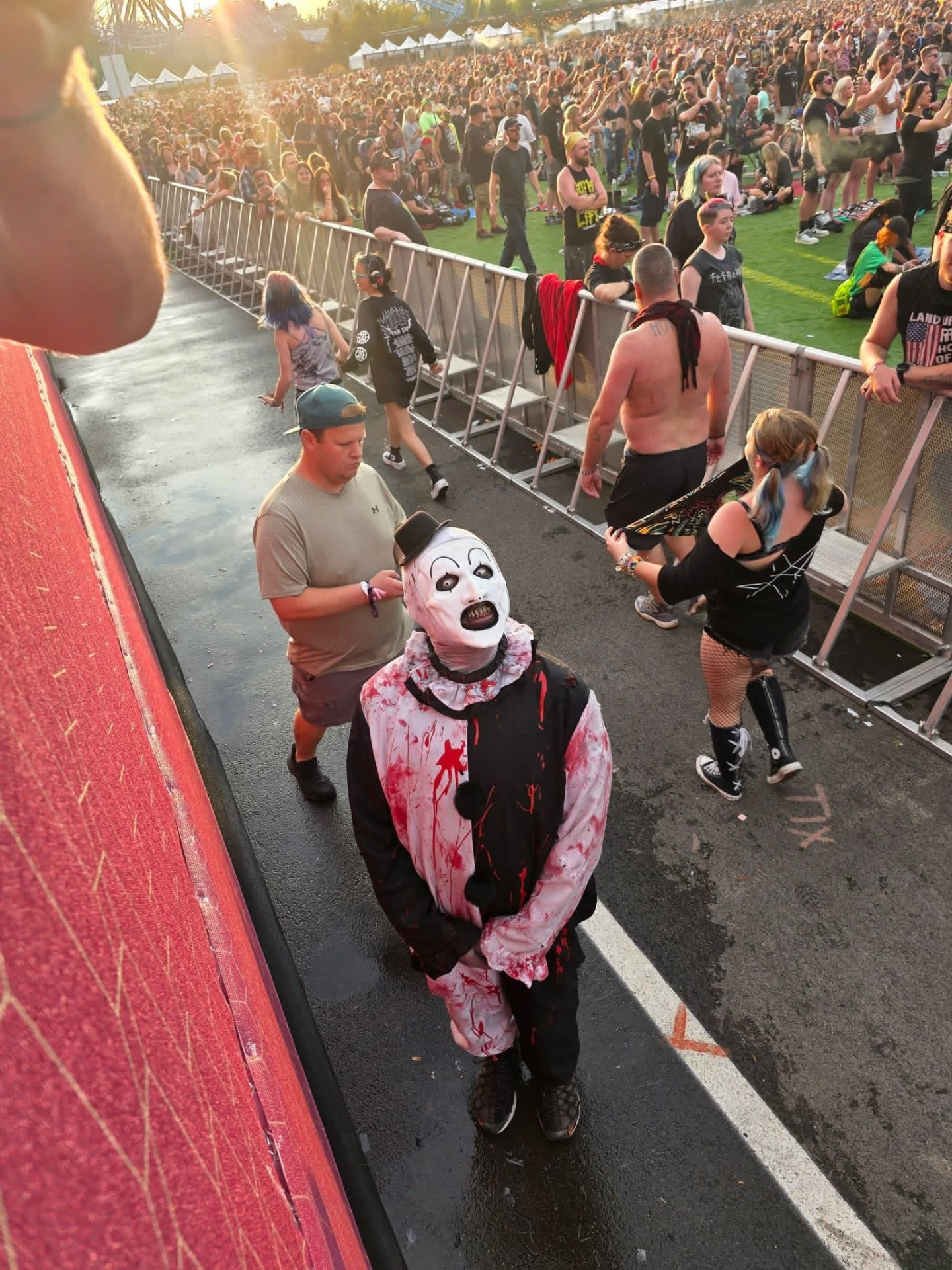 Golden hour: Art the Clown walking the barricade ramp above the festival crowd