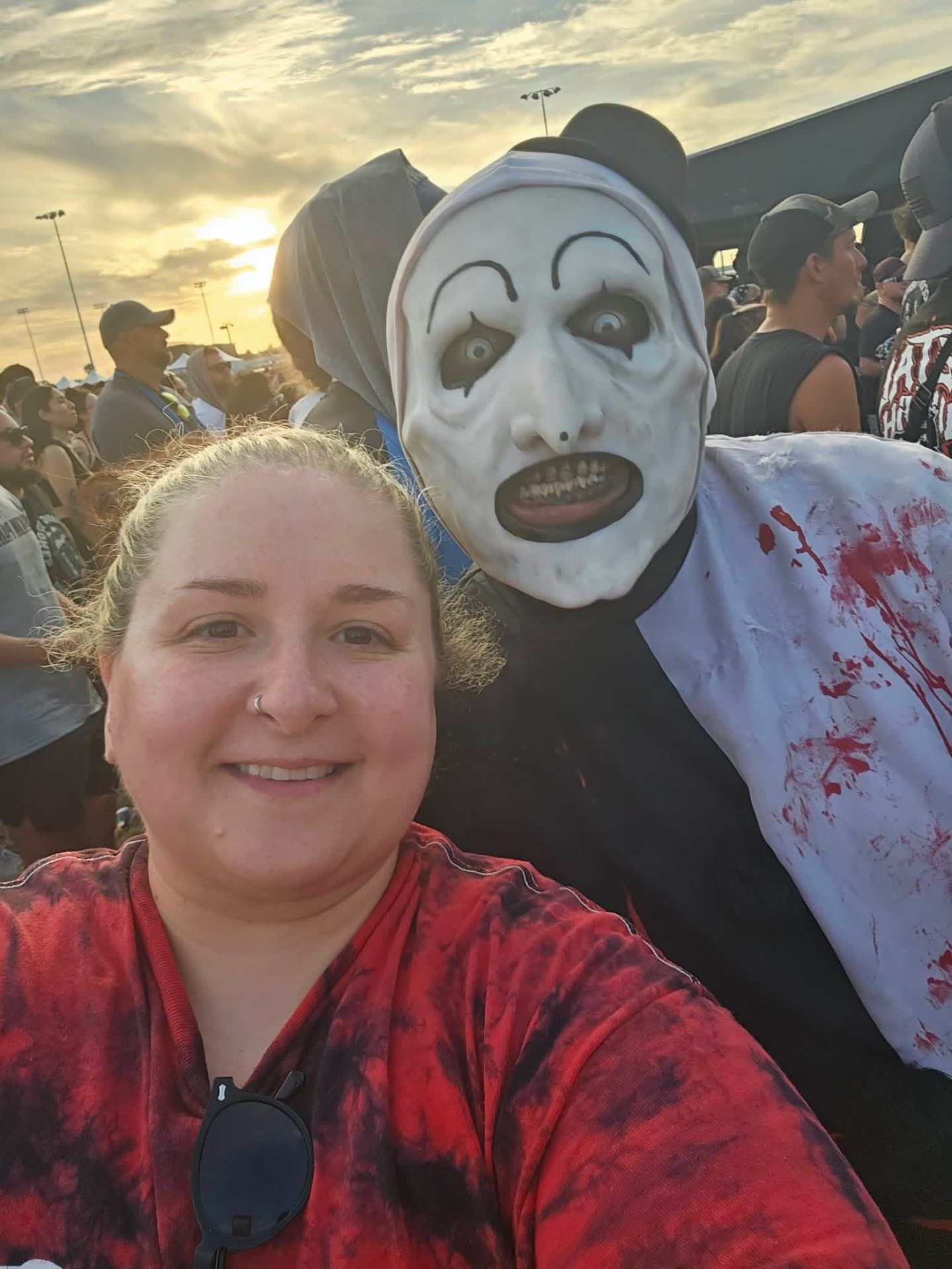 Golden-hour selfie: Art the Clown behind a smiling fan in a red tie-dye shirt