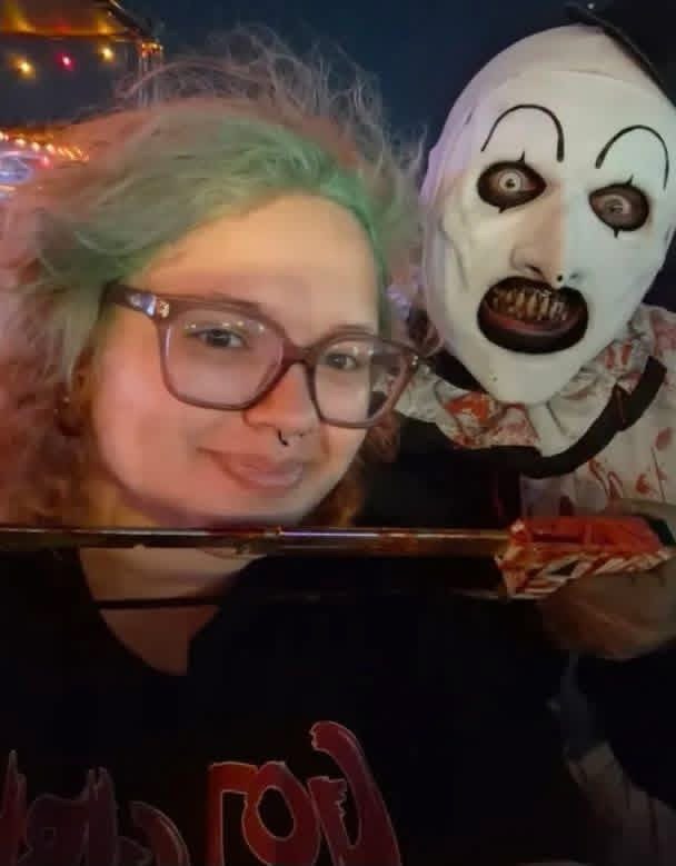 Night selfie: Art the Clown holding a blade under a fan with green hair