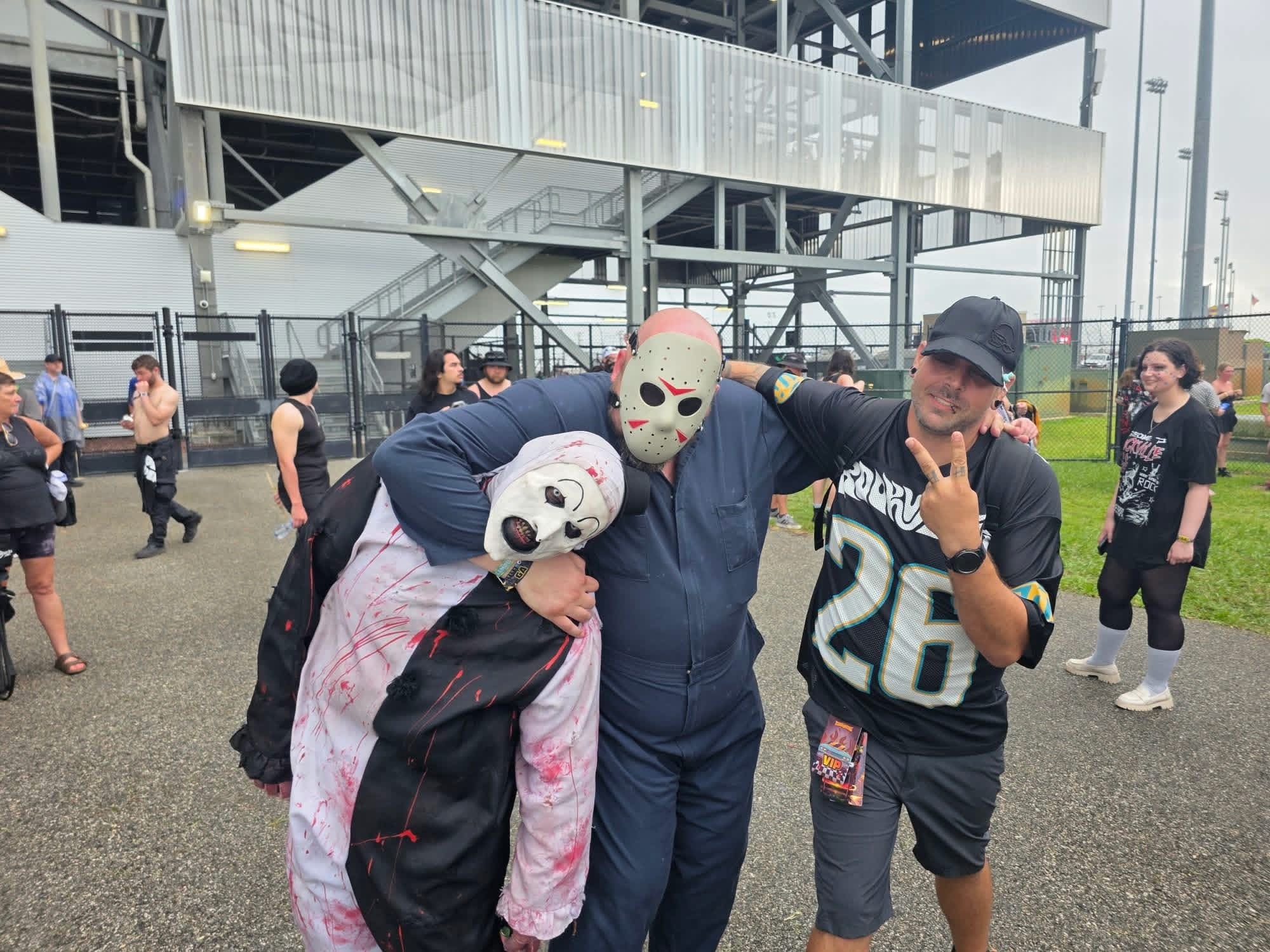 Art the Clown headlocked by a fan in a hockey mask next to a fan in a Rockville jersey