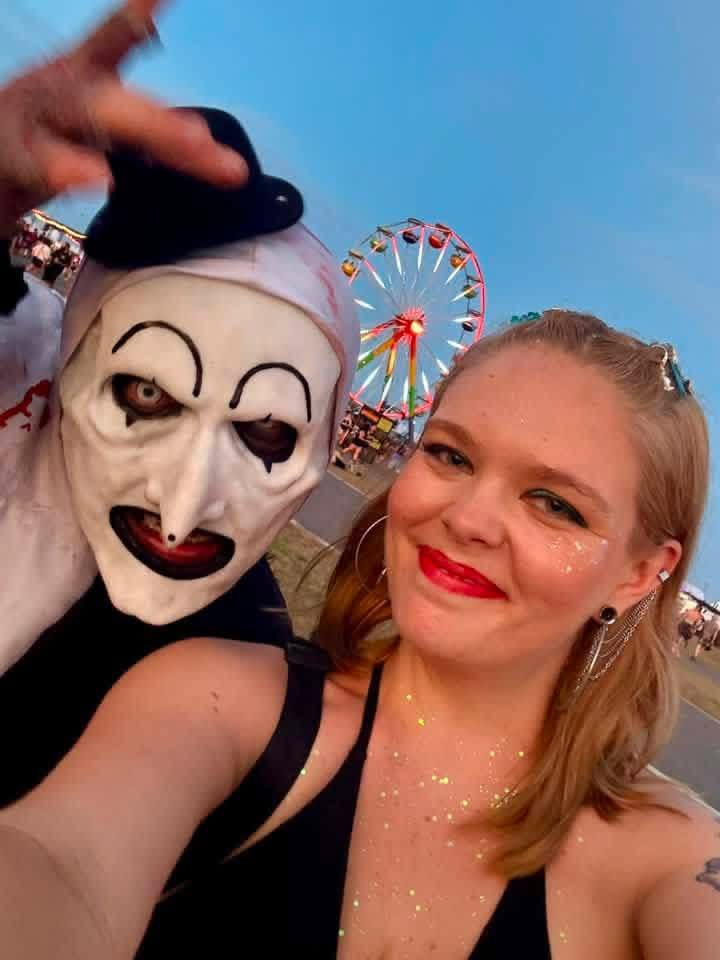 Golden-hour selfie: Art the Clown with a glittered fan by the ferris wheel